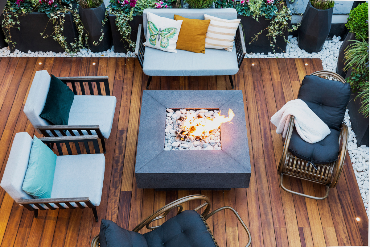 Overhead view of a timber deck with a fire table and outdoor chairs and loveseat with custom cushions