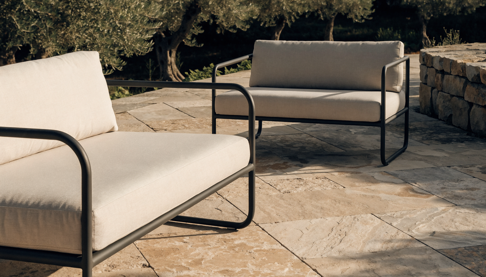 Deep seat outdoor sofa cushions beside a standard-depth loveseat on a sunny terrace
