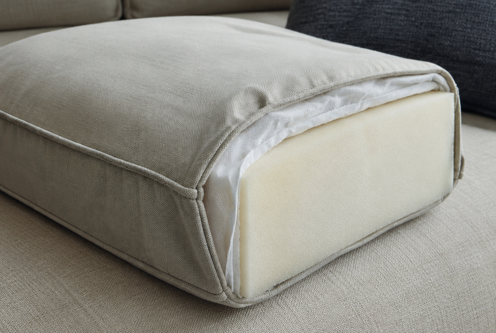 Close-up of a well-made premium cushion cut open to show dense foam core, quality cover with welted seams