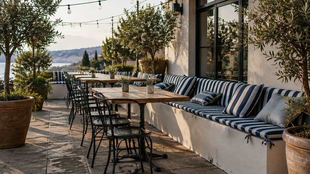 Restaurant patio with metal dining chairs and navy outdoor seat cushions tied in place under string lights