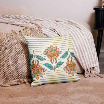Bliss Chintz pillow, 18 x 18 in, cream striped side with orange and teal florals on a bed with a striped throw