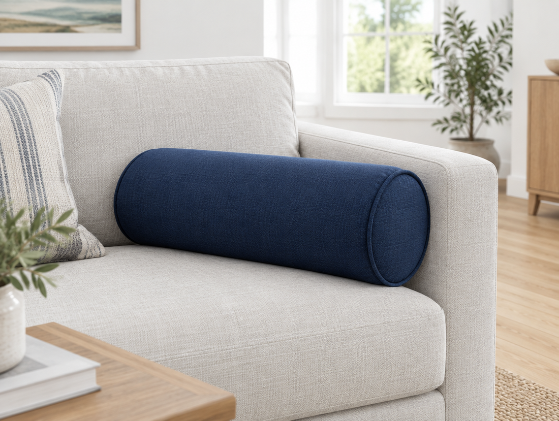 Custom bolster cushion in navy Sunbrella fabric on a sofa arm